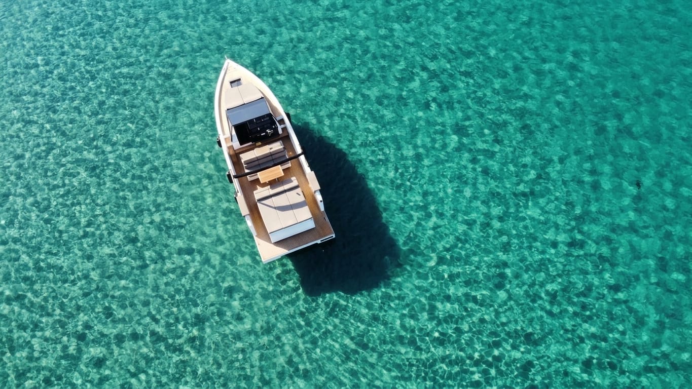 Bateau à moteur vu du ciel sur une eau turquoise